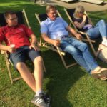 3 Besucher sitzen in Gartenstühlen